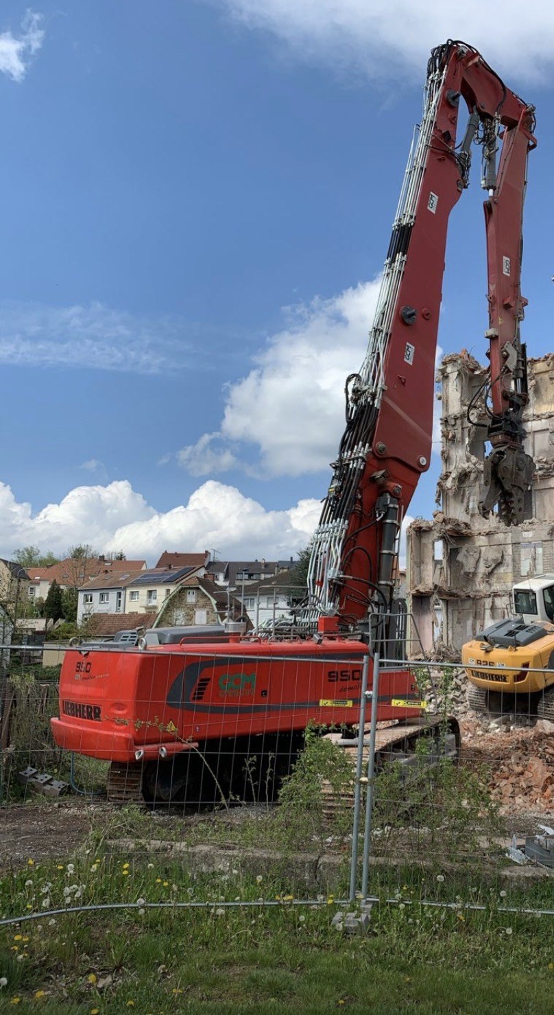 Pelle de démolition longue portée abattant une maison